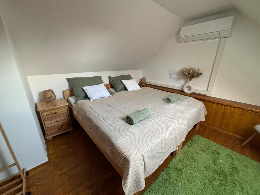 a bedroom with a large bed with a green rug at Niki Tóparti Pihenő in Gyékényes
