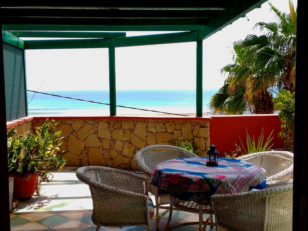 een tafel en stoelen op een patio met uitzicht op de oceaan bij Ibiscus Penthouse in Santa Maria