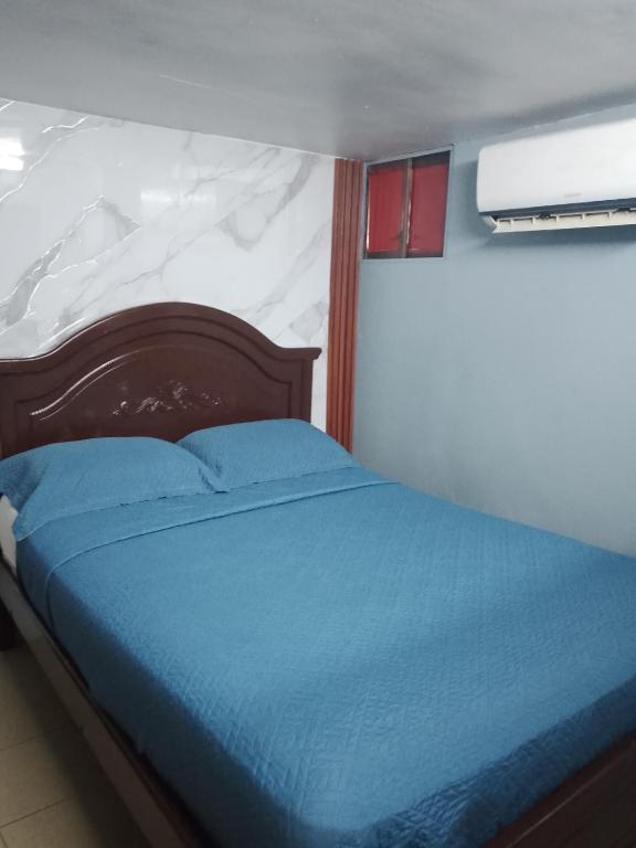 a bedroom with a bed with a blue bedspread at Hotel tower one in Guayaquil