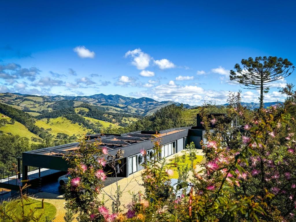 a house on a hill with mountains in the background at casa mantiqueira in Gonçalves