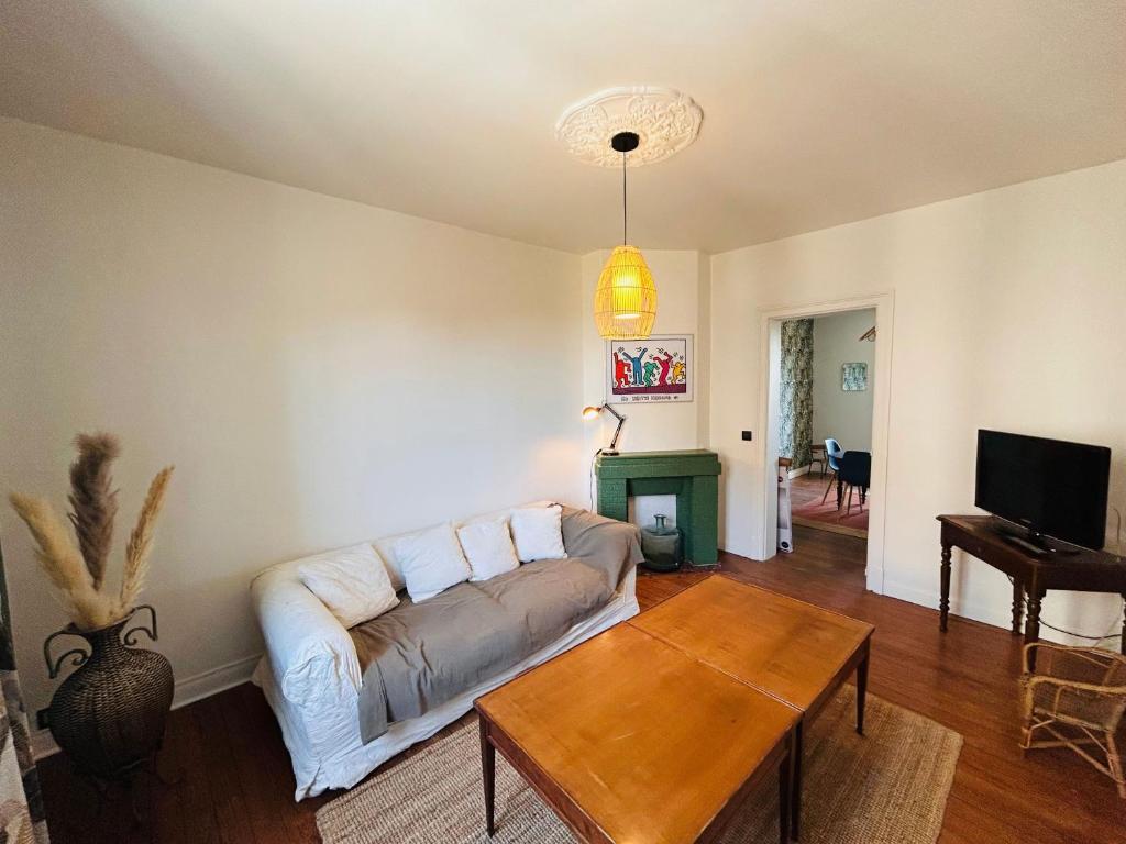 a living room with a couch and a table at 6 benoit in Reims