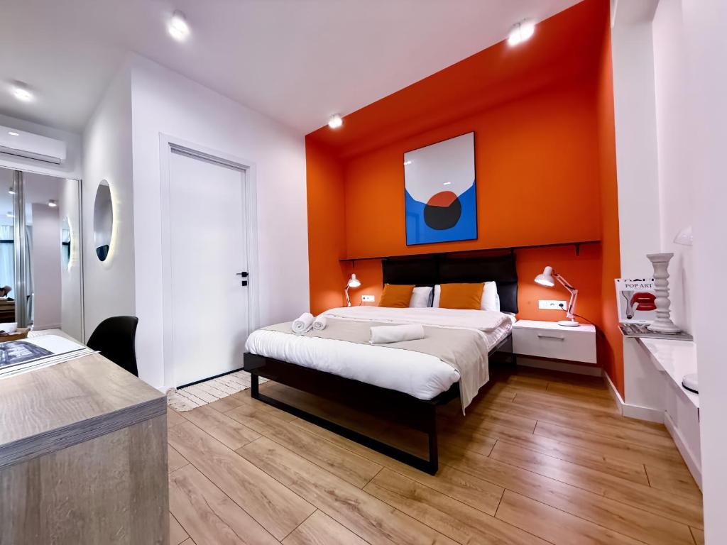 a bedroom with a bed and an orange wall at Vere Side Rooms in Tbilisi City