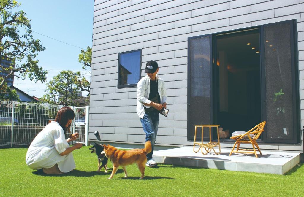 a man and a woman with a dog in a yard at Izumo-shuku MAICHI STAY - Vacation STAY 69539v in Izumo