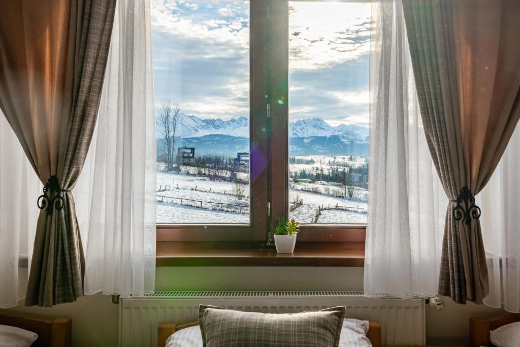 a window with a view of snow covered mountains at Willa Leśny Potok in Poronin
