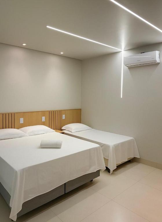 two beds in a room with white walls at Villa Hotel in Bom Jesus da Lapa