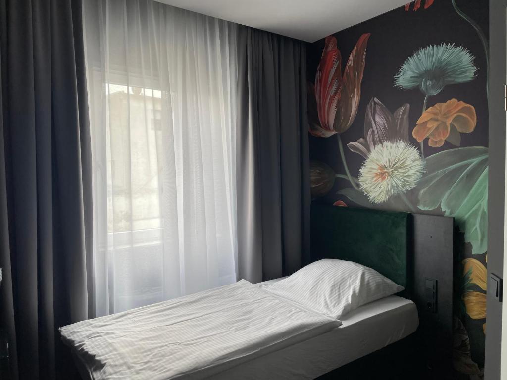 a small bed in a room with a window at Hotel Elsen in Grevenbroich