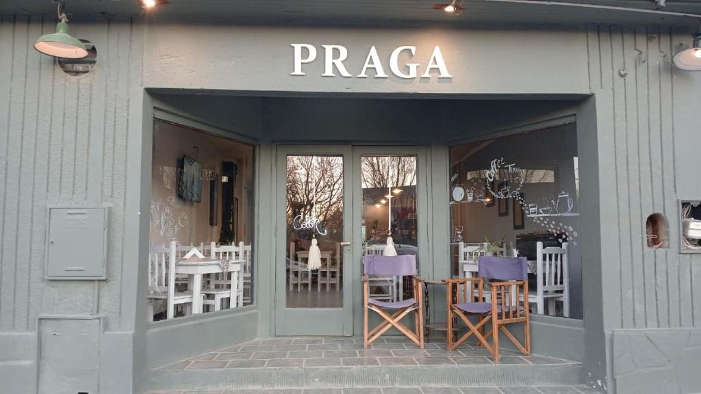 Un restaurante con sillas y mesas moradas en la entrada. en Praga Hotel, en Puerto San Julián