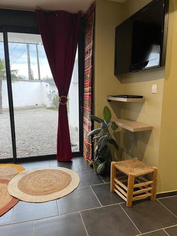 a living room with a flat screen tv on a wall at Studio privé tout équipé in Roquefort-sur-Garonne