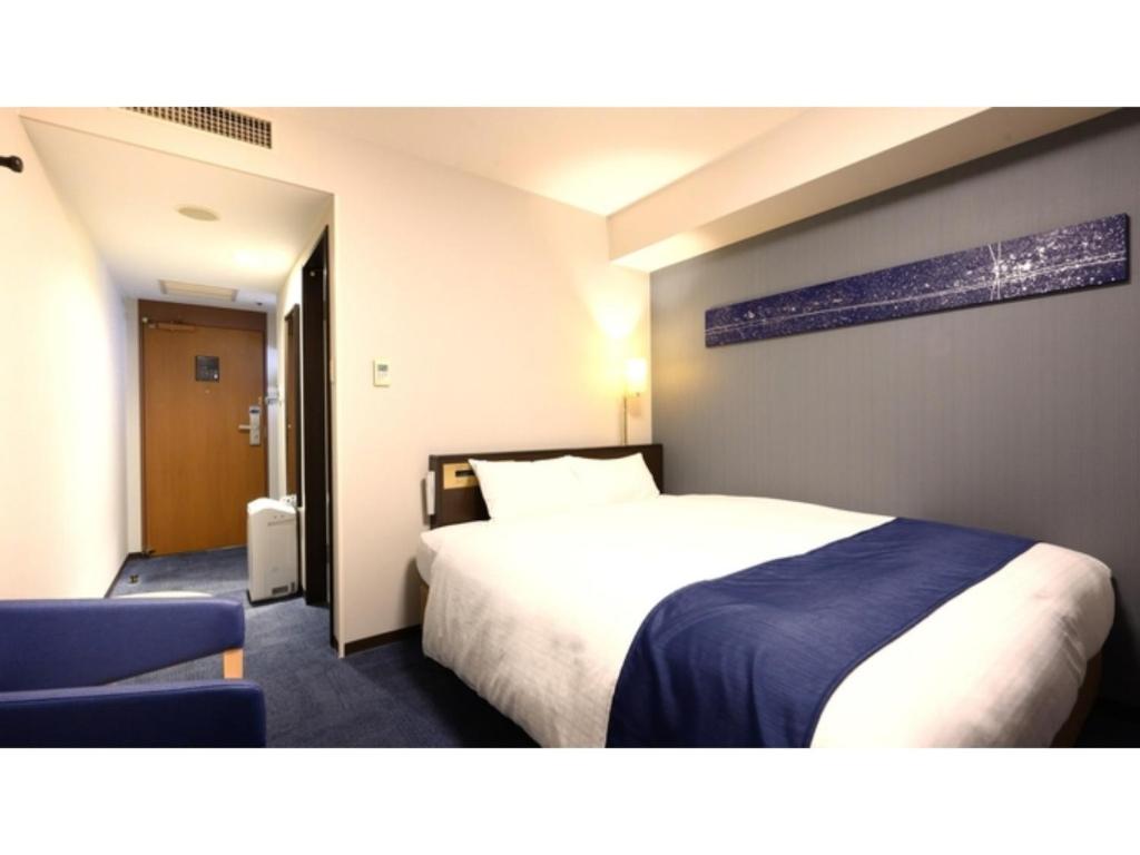 a hotel room with a bed and a chair at Smile Hotel Premium Kanazawa Higashiguchi Ekimae - Vacation STAY 65342v in Housai