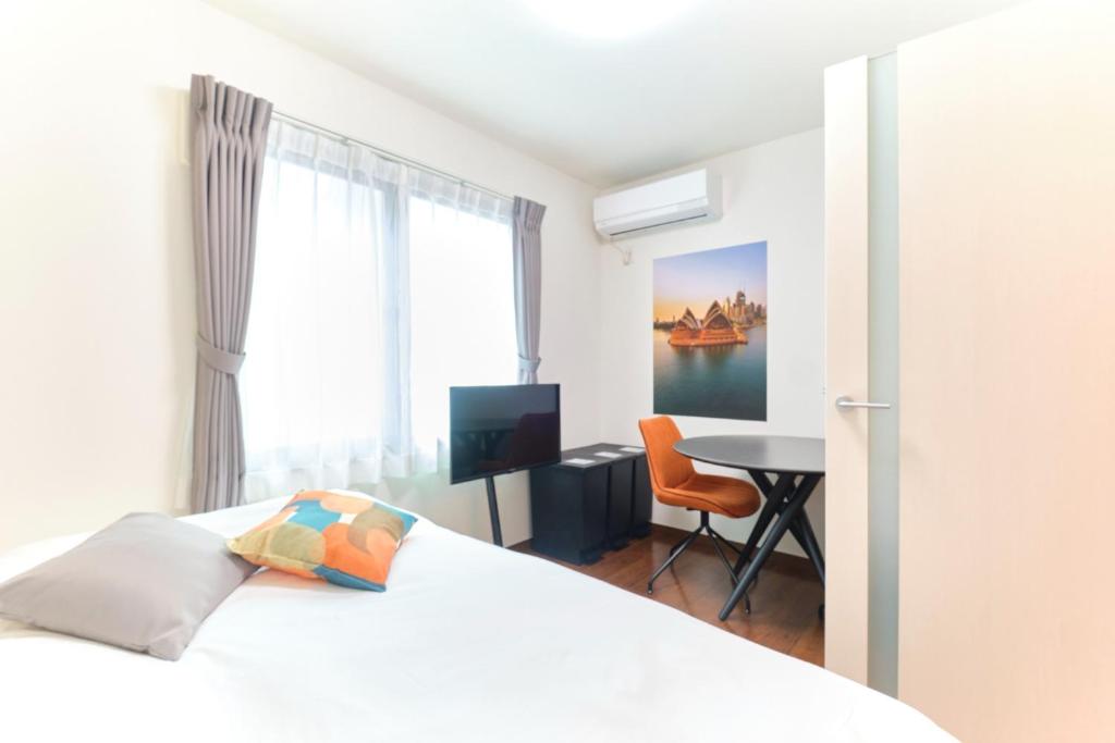 Un dormitorio con una cama, un escritorio y una mesa. en le cocon Nakarokugo - Vacation STAY 17419v, en Tokio
