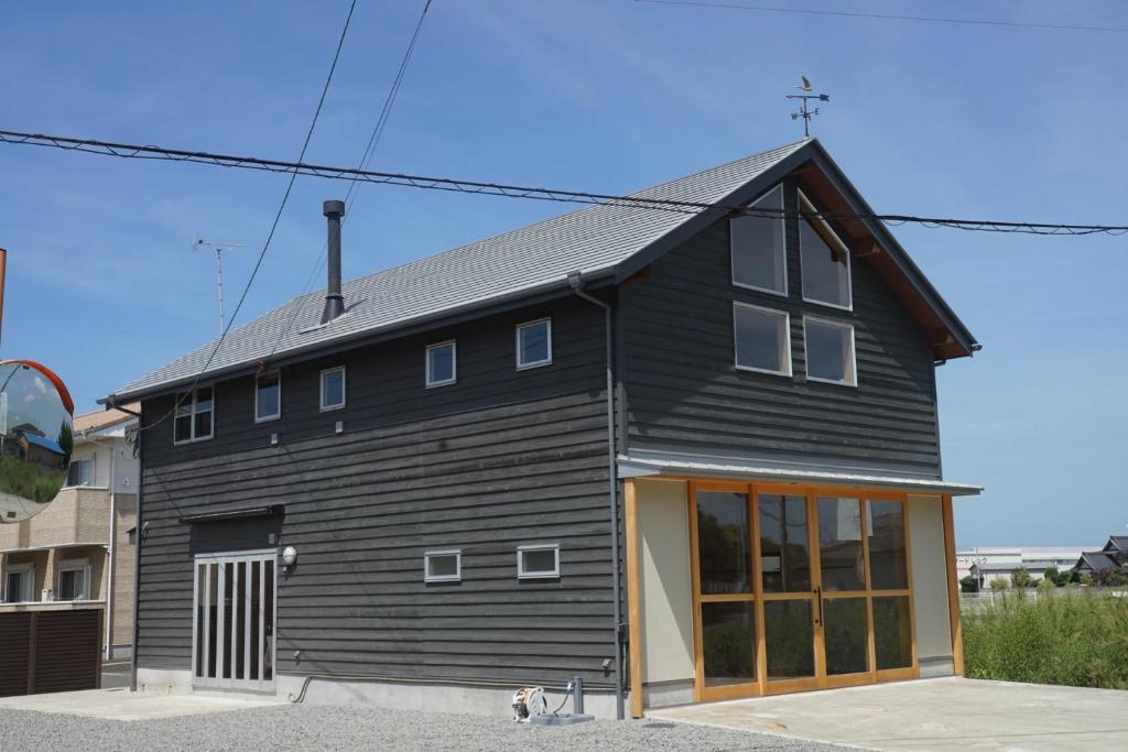 ein schwarzes Haus mit einem großen Fenster in der Unterkunft Guesthouse 191 - Vacation STAY 50521v in Kanonji