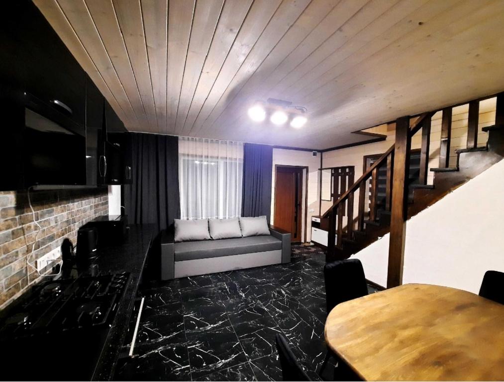 a living room with a couch and a table at Подих Карпат in Volosyanka