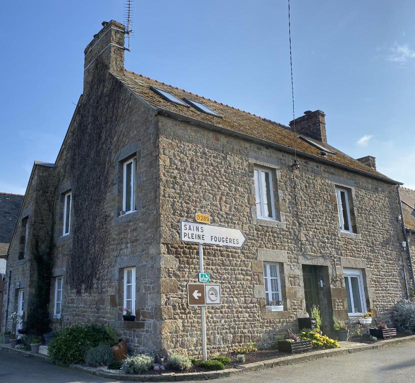a stone building with a street sign in front of it at Rêve du Revert in Roz-sur-Couesnon