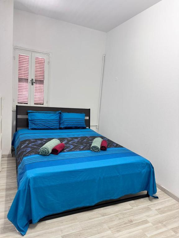 a bedroom with a blue bed with two pillows on it at Near Finikoudes Beach 15 in Larnaca