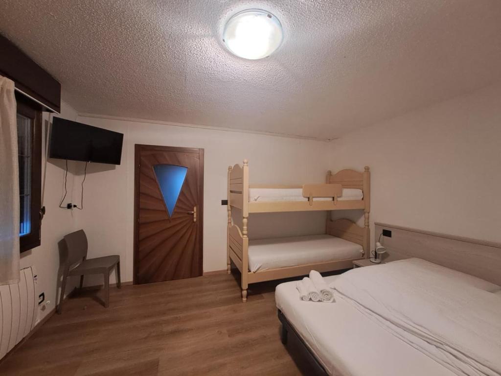 une chambre avec un lit et un lit superposé et une porte dans l'établissement casa Veronica, à Pieve Di Ledro