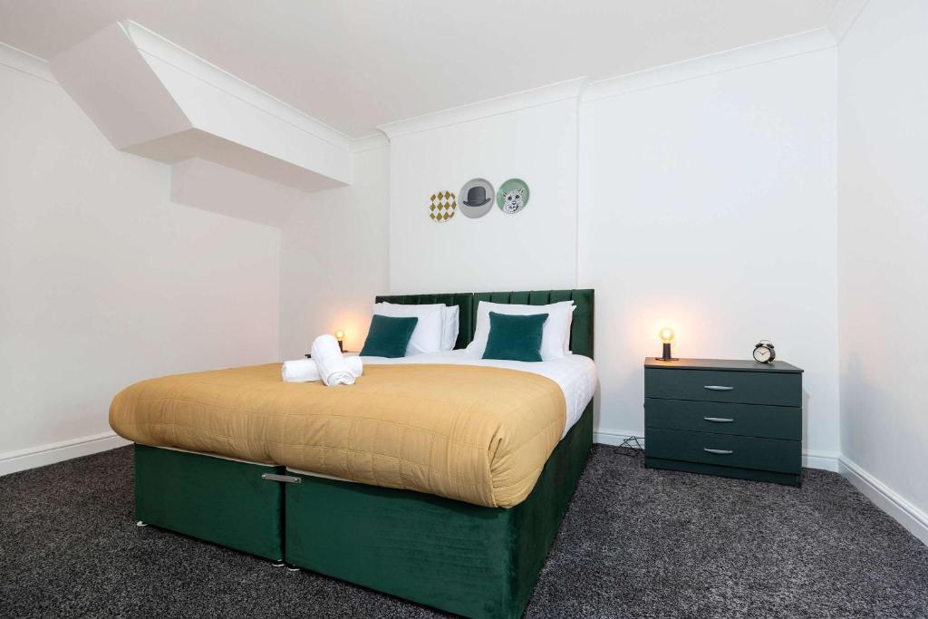 a bedroom with a large bed with green and white pillows at Contractor Stay - 4 Beds Games Room Secure Parking in Bishop Auckland
