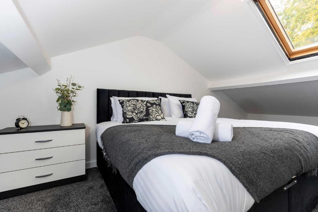 ein Schlafzimmer mit einem schwarzen und weißen Bett und einer Kommode in der Unterkunft Contractor Stay - 4 Beds Games Room Secure Parking in Bishop Auckland