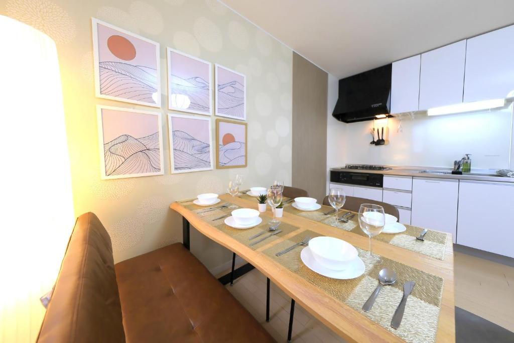 a kitchen with a wooden table with plates and wine glasses at Kapalua East-Kapalua West - Vacation STAY 20388 in Tokyo