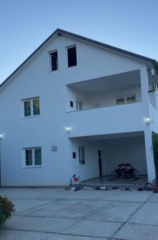 a large white building with a large garage at Bujtina e Kadrise in Kukës