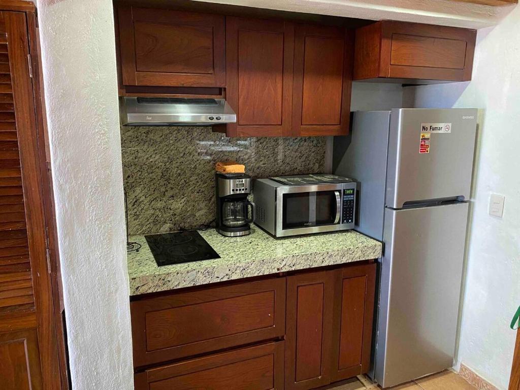 een kleine keuken met een magnetron en een koelkast bij Madchen in Puerto Vallarta