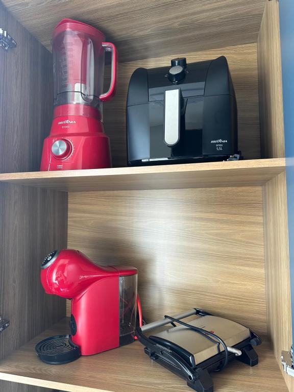 パリョサにあるApartamento NOVO e moderno em palhoçaの赤いブレンダーとトースターが置かれたキャビネット