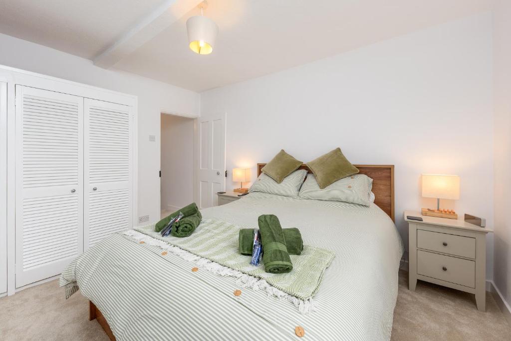 - une chambre avec un lit blanc et des serviettes vertes dans l'établissement cottage in the heart of Canterbury amazing Cathedral views, à Canterbury