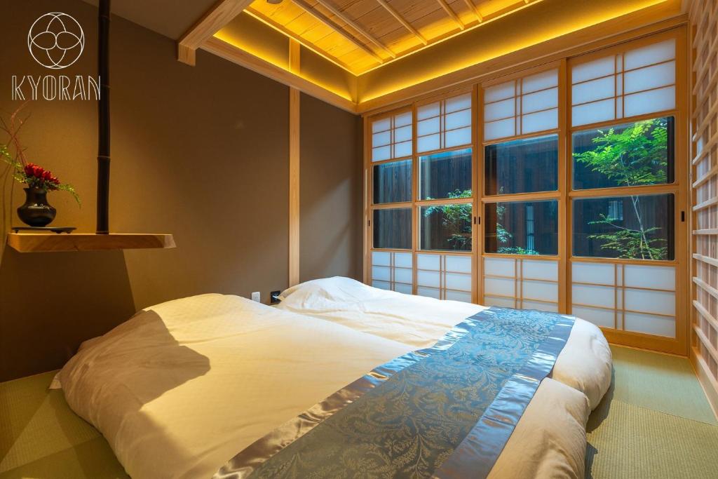 ein Schlafzimmer mit einem großen Bett vor einem Fenster in der Unterkunft [Kyoran Touen Residence] - Vacation STAY 65169v in Kyōto