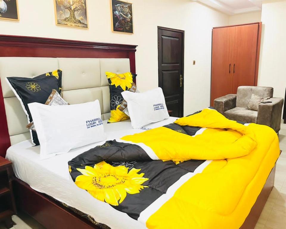 にあるPharrell Luxury Hotelの大型ベッド(黄色の毛布付)