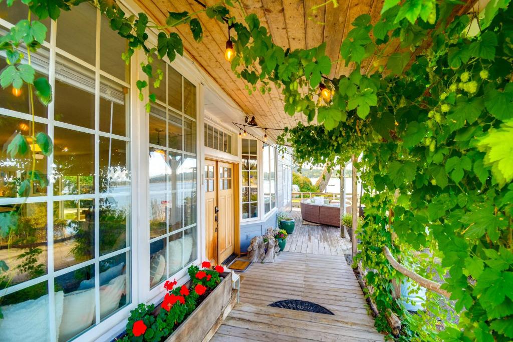 Un porche de una casa con flores y enredaderas. en Gig Harbor House with Private Beach and Views!, en Gig Harbor