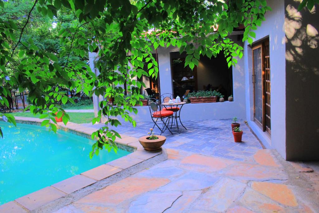 a patio with a table and chairs next to a pool at 8 at Norman Crescent in Johannesburg