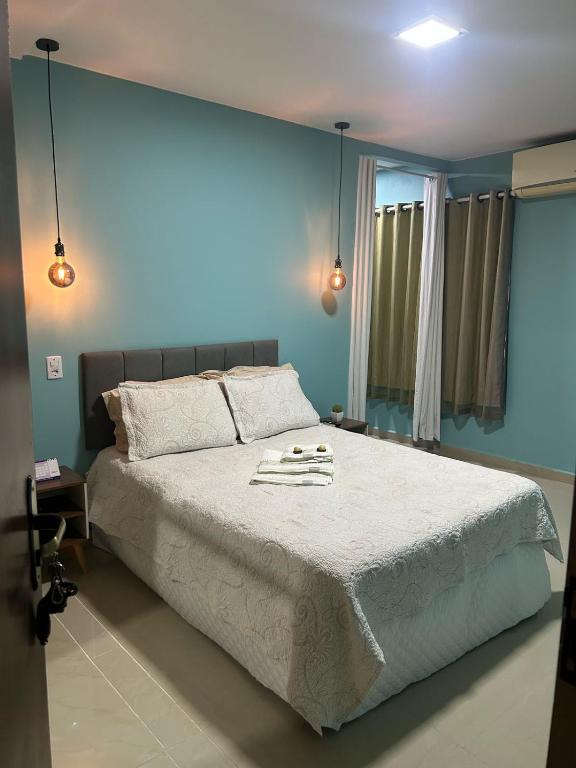 马瑙斯Conforto Versalles的卧室里有一张大床，墙壁是蓝色的