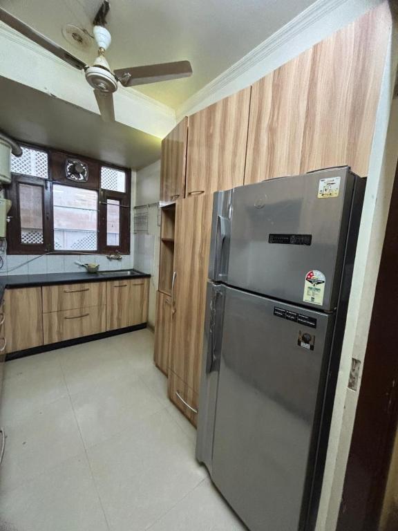 eine Küche mit Edelstahlkühlschrank und Holzschränken in der Unterkunft The Modern Monastery in Jaipur