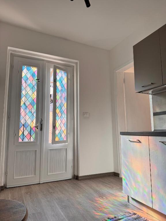 an empty room with two stained glass doors at Casa Kokoro in Staranzano