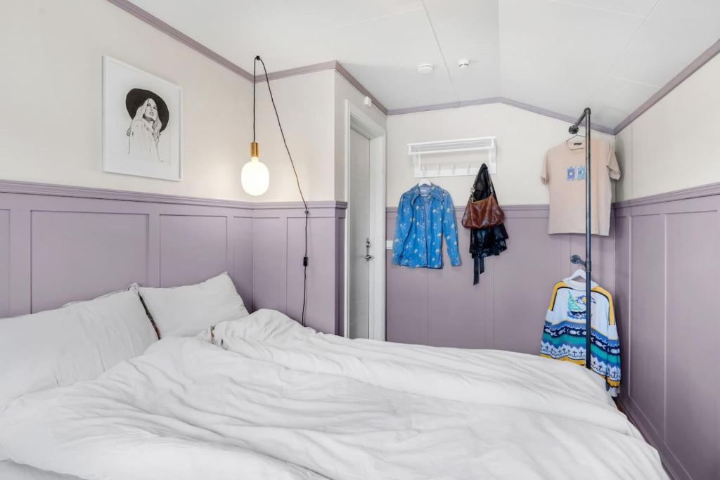 a bedroom with a white bed with purple walls at Arctic hilltop lodge - Room 1 in Guleng