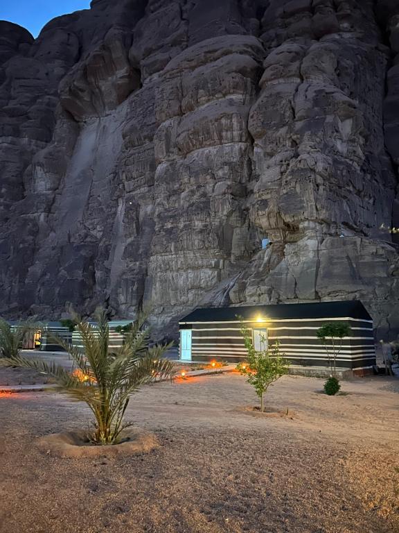 un edificio frente a una montaña por la noche en Wadi Rum Sarab Camp, en Disah