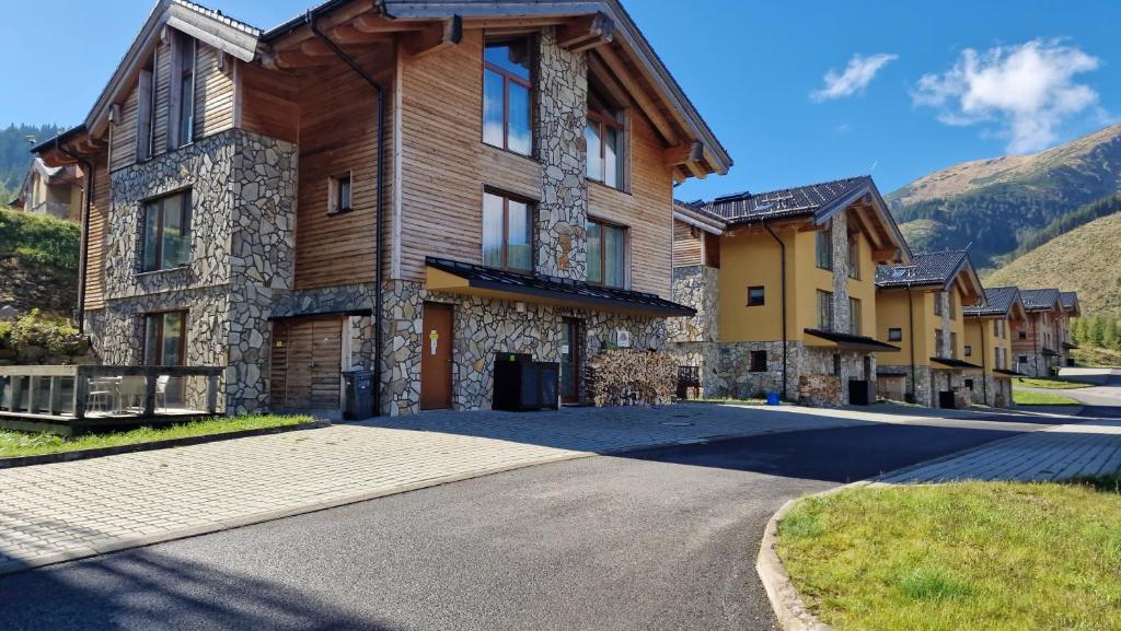 a home in the mountains with a driveway at Apartment ALFA with jacuzzi in Demanovska Dolina