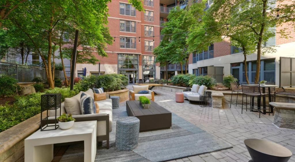 an outdoor patio with couches and tables and trees at The Stay 2 - Navy Yard Washington DC in Washington