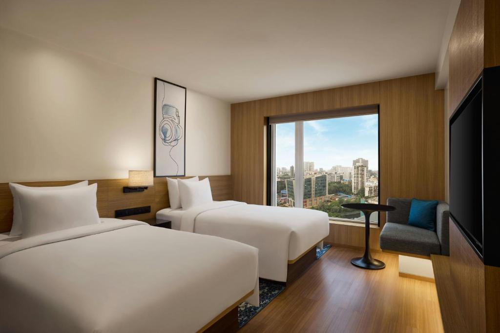 a hotel room with two beds and a window at Fairfield by Marriott Mumbai Andheri West in Mumbai