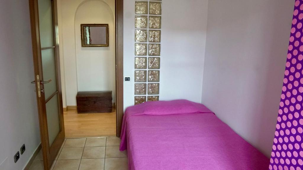 a small bedroom with a purple bed in a room at La Casa di Anita in Asti