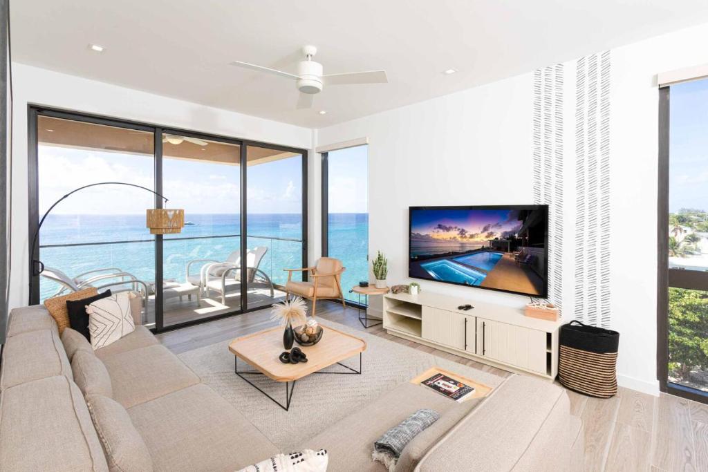SeaDreams 8 في West Bay: غرفة معيشة مع أريكة وتلفزيون ونوافذ