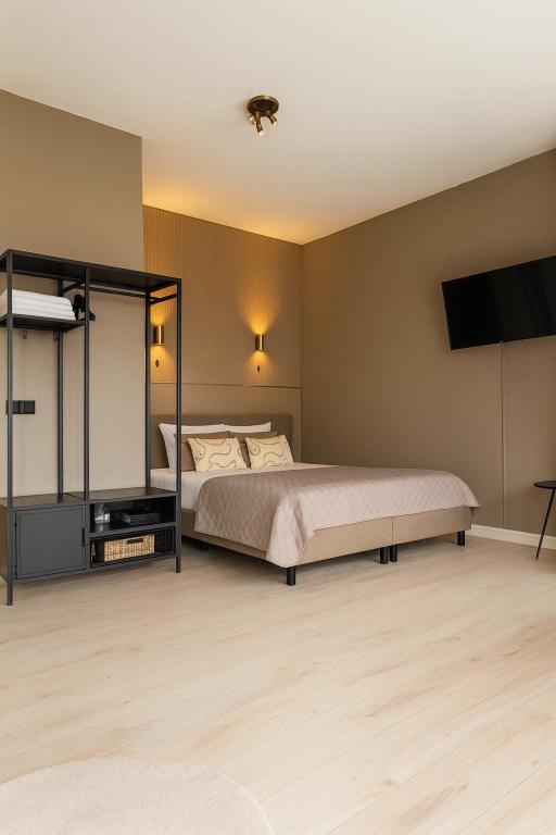a bedroom with a bed and a flat screen tv at Manor Suite Amsterdam in Amsterdam