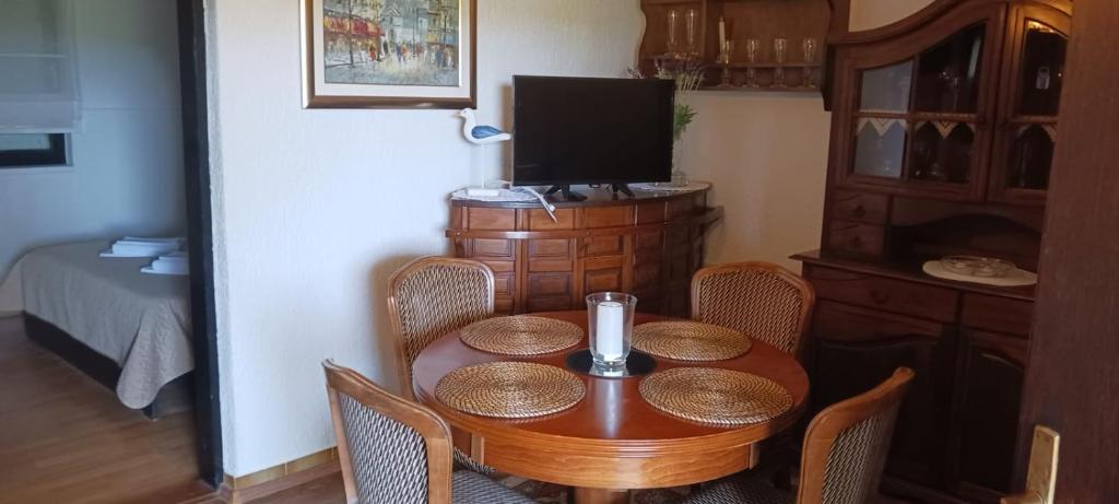 a room with a table with chairs and a television at Apartmani Kolić in Rab