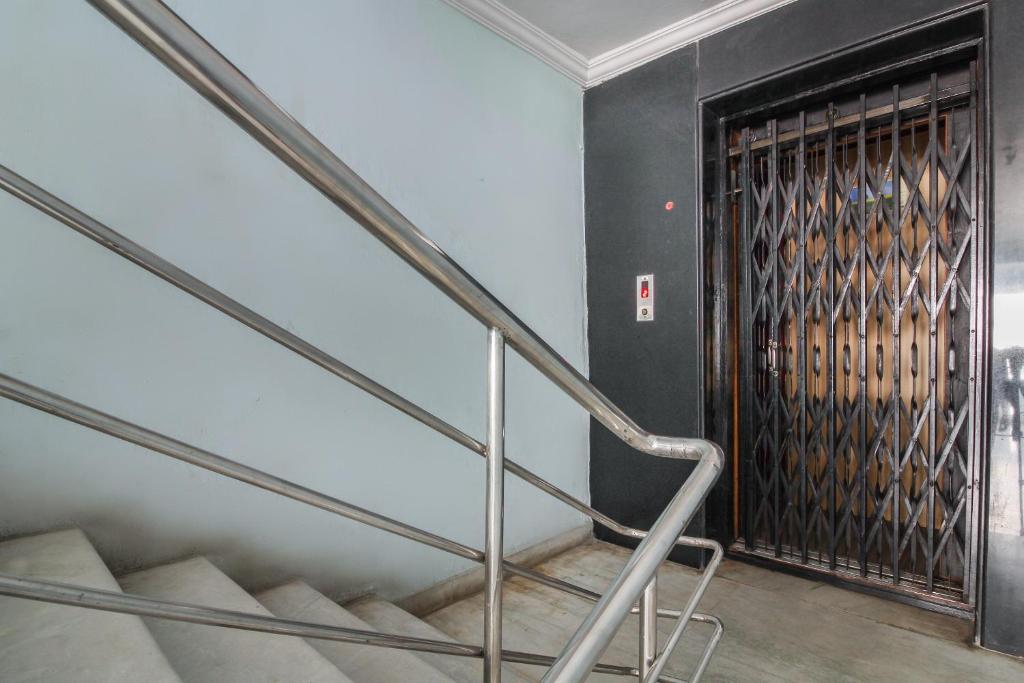 a staircase with a metal railing and a door at Hotel O Krupa Service Apartments in Hyderabad