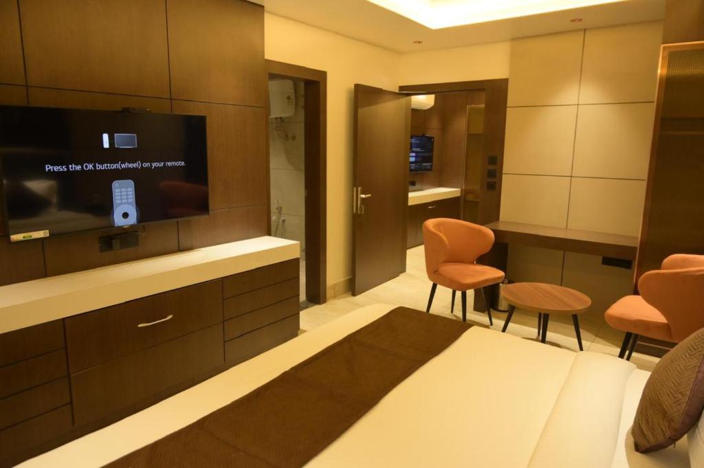 a hotel room with a bed and a tv and chairs at Diesel inn hotel in Hanumāngarh