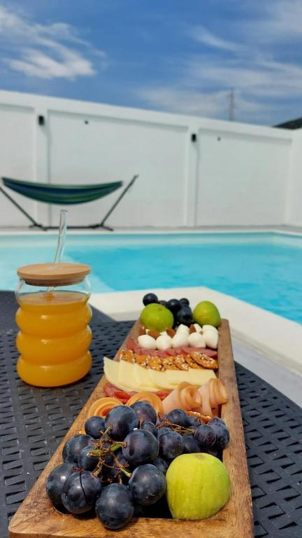 a tray of fruit on a table next to a pool at Sun&Silence in Mostar