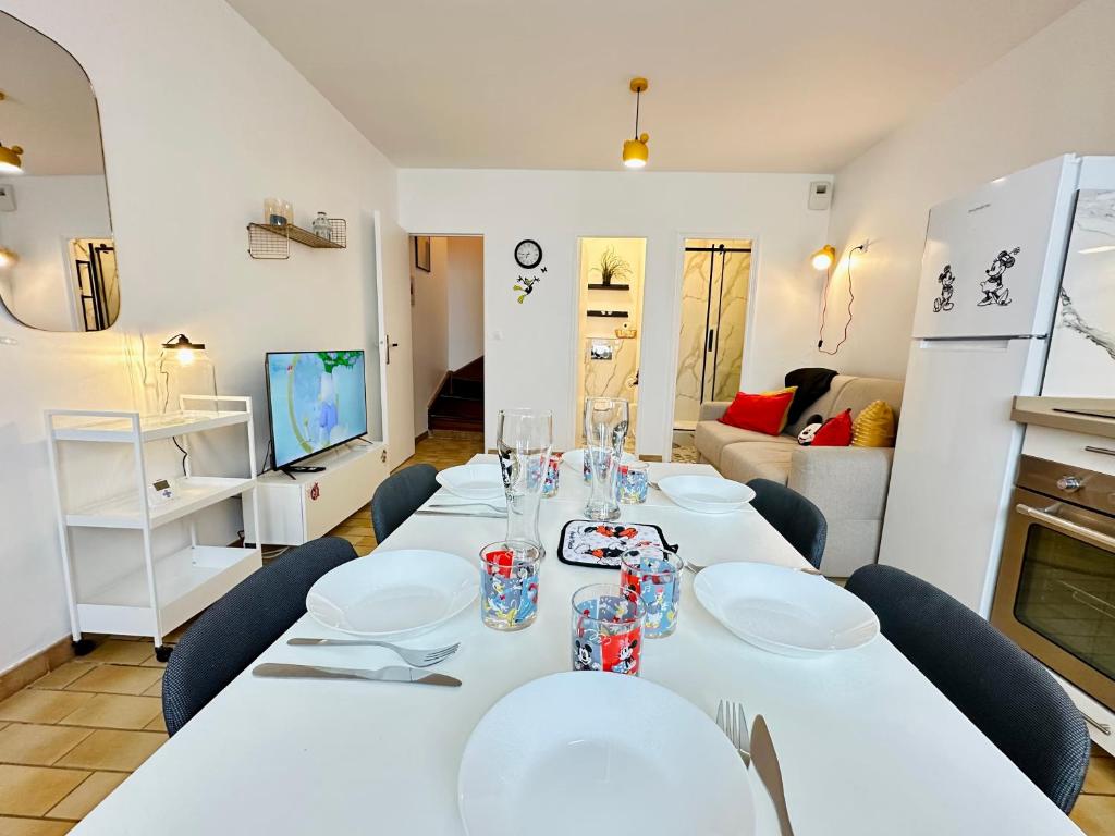 Un comedor con mesas blancas y sillas azules. en La Maison de Mickey - Disneyland Paris, en Bailly-Romainvilliers