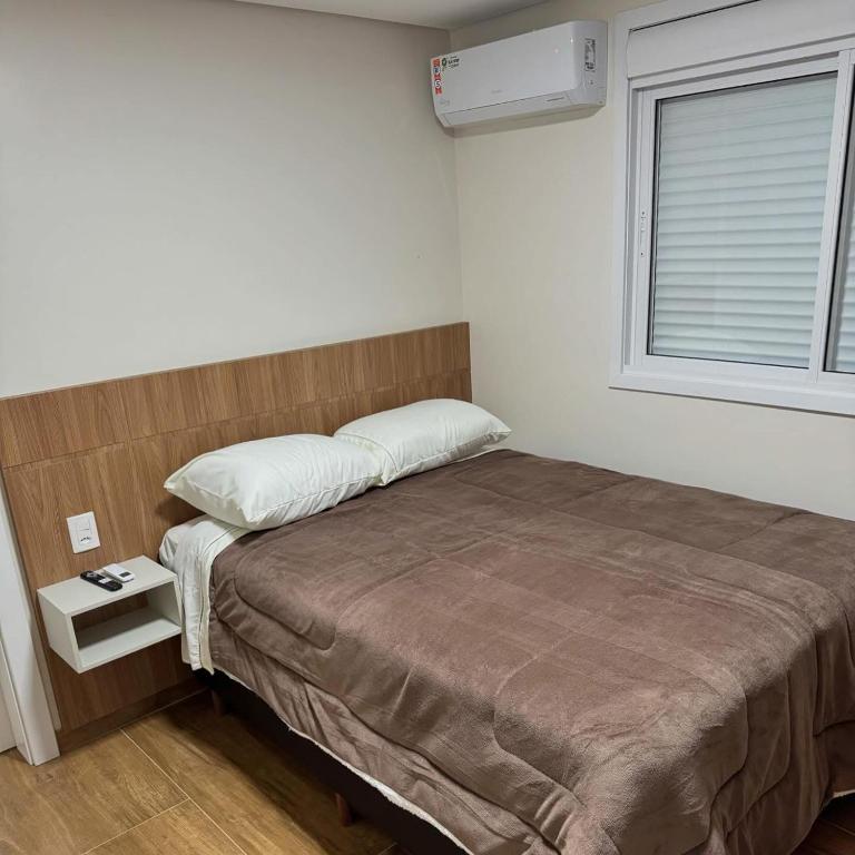 a small bedroom with a bed and a window at Restaurante e Pousada Andrade 