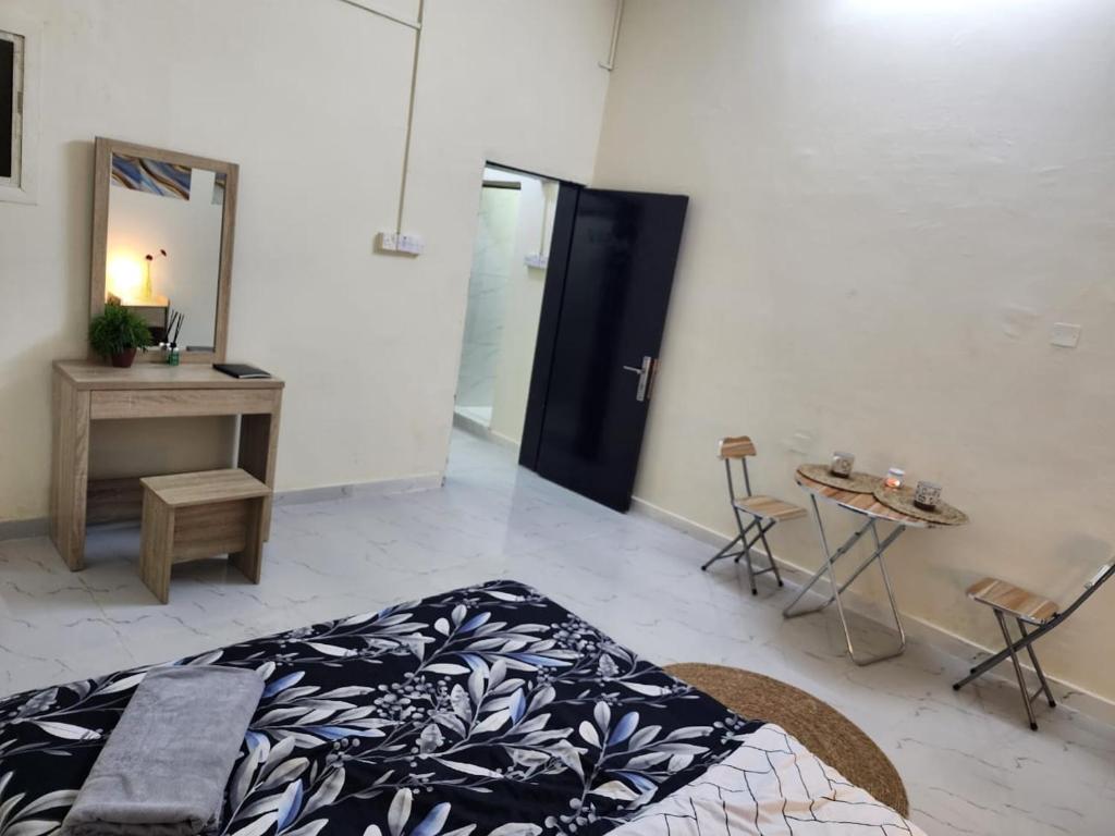 a bedroom with a bed and a table and a mirror at studio near al ain mall in Al 'Ayn