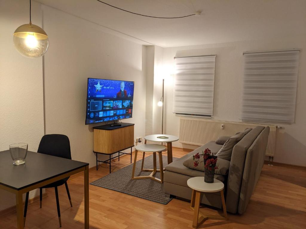 a living room with a couch and a flat screen tv at K&K City-Apartment in Weimar