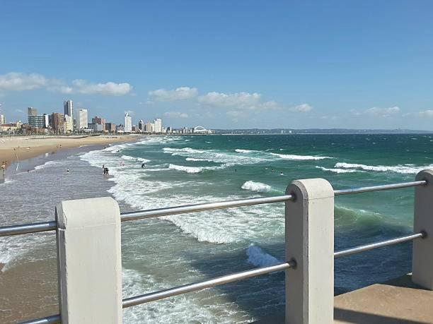 a view of the ocean with a beach and buildings at Overflowing Guest House in Durban